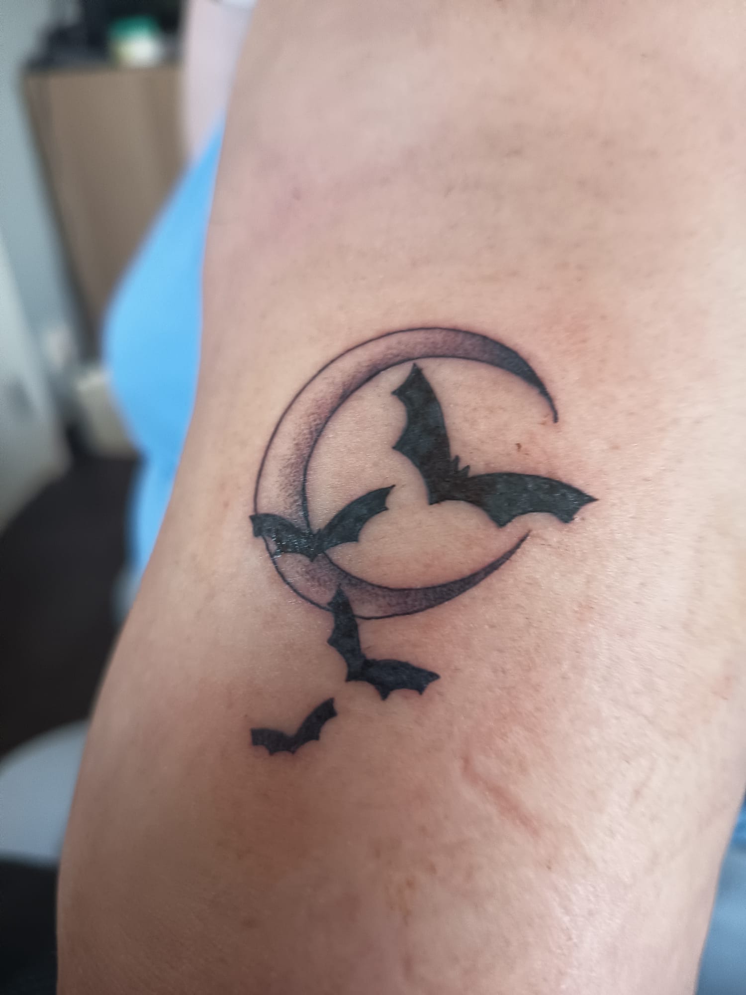 Tatoeage van een maan en 4 vleermuizen. 